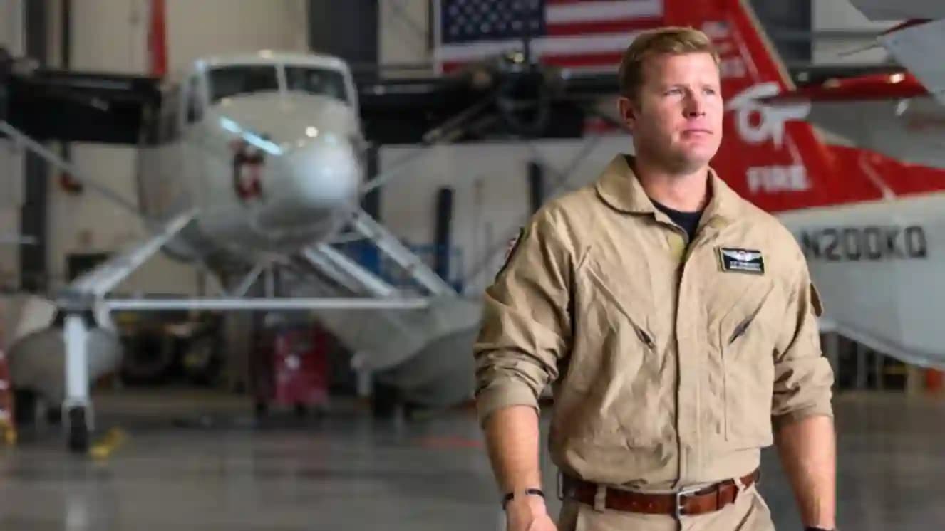 Tom Sheehy shot details released. Tom standing next to a military plane.