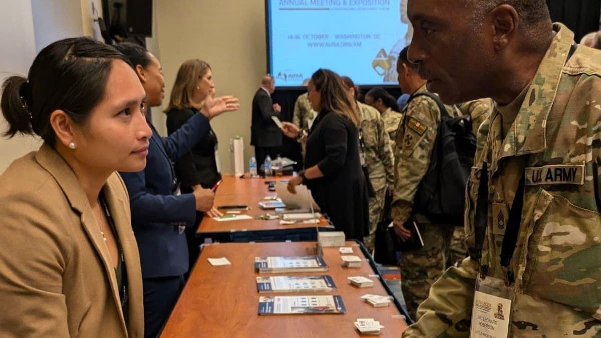 A plain-clothed man and woman chat at a retirement planning fair.
