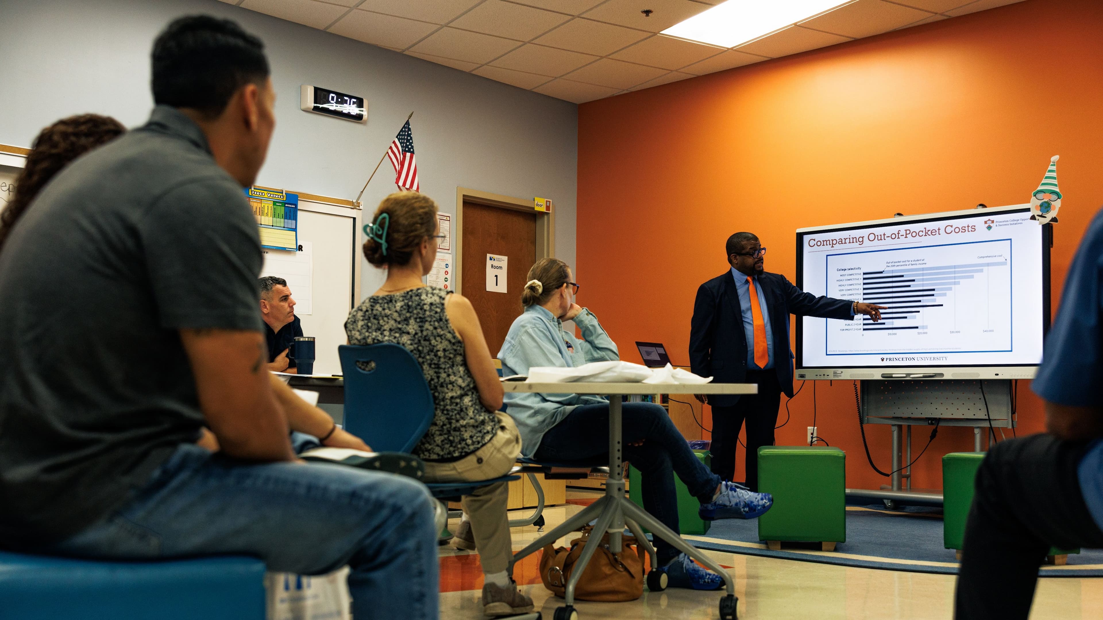 Parents of students sit in a classroom.