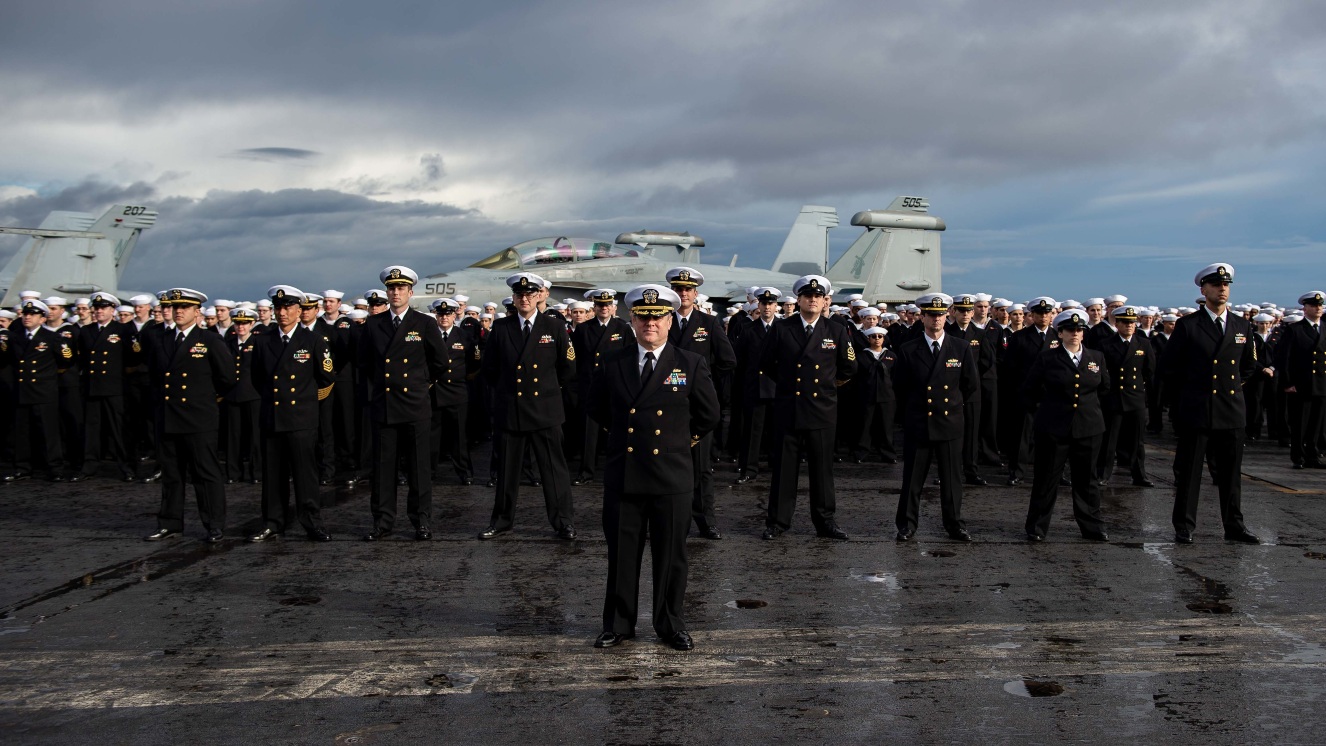 Navy Sailors from the branch of the United States Uniformed Services that controls the seas pose for a photo during a dress uniform inspection on the USS Carl Vinson.