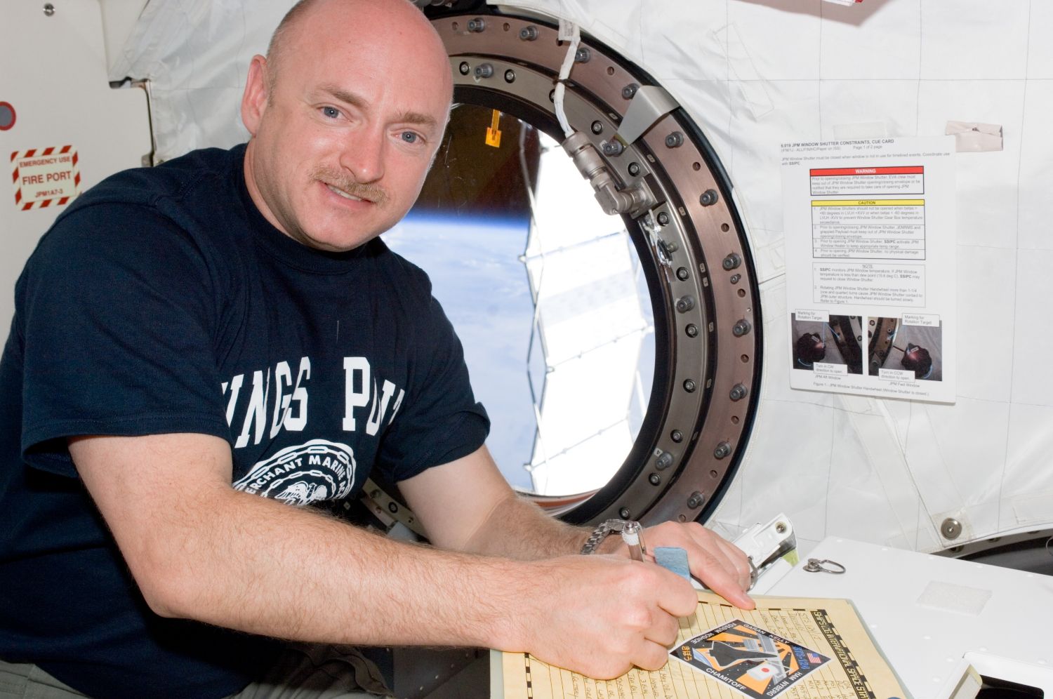 Astronaut Mark Kelly, STS-124 commander, makes an entry in the International Space Station ships log in the Japanese Experiment Module (JEM) Pressurized Module.