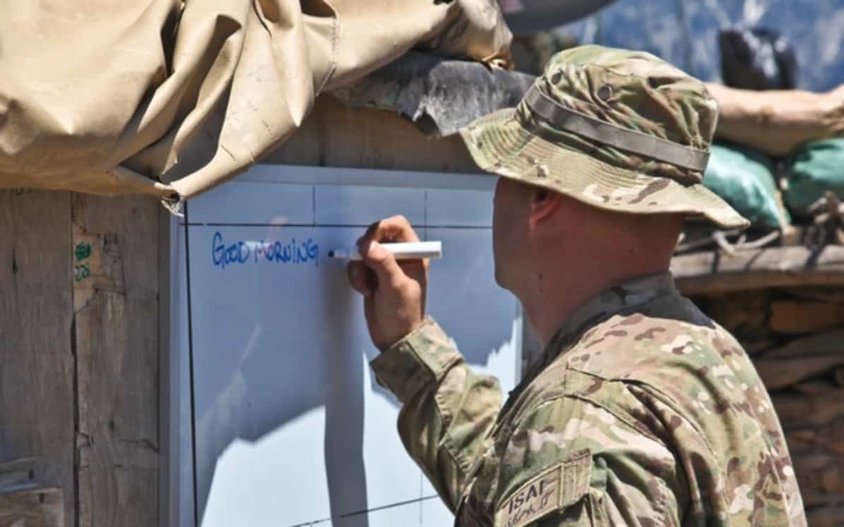 U.S. Army Staff Sgt. Robert Cossairt writes English phrases on a dry erase board during a Pashto/English class.