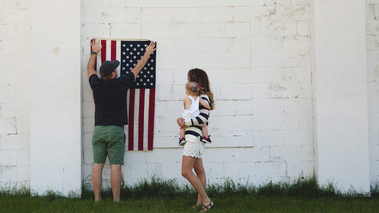 A couple hangs an American flag in honor of PTSD awareness.