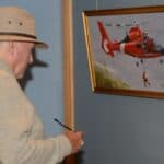 A visitor to the Coos History Museum looks at a piece of art from the Coast Guard Art Program. Military arts and crafts programs have helped troops since WWII.