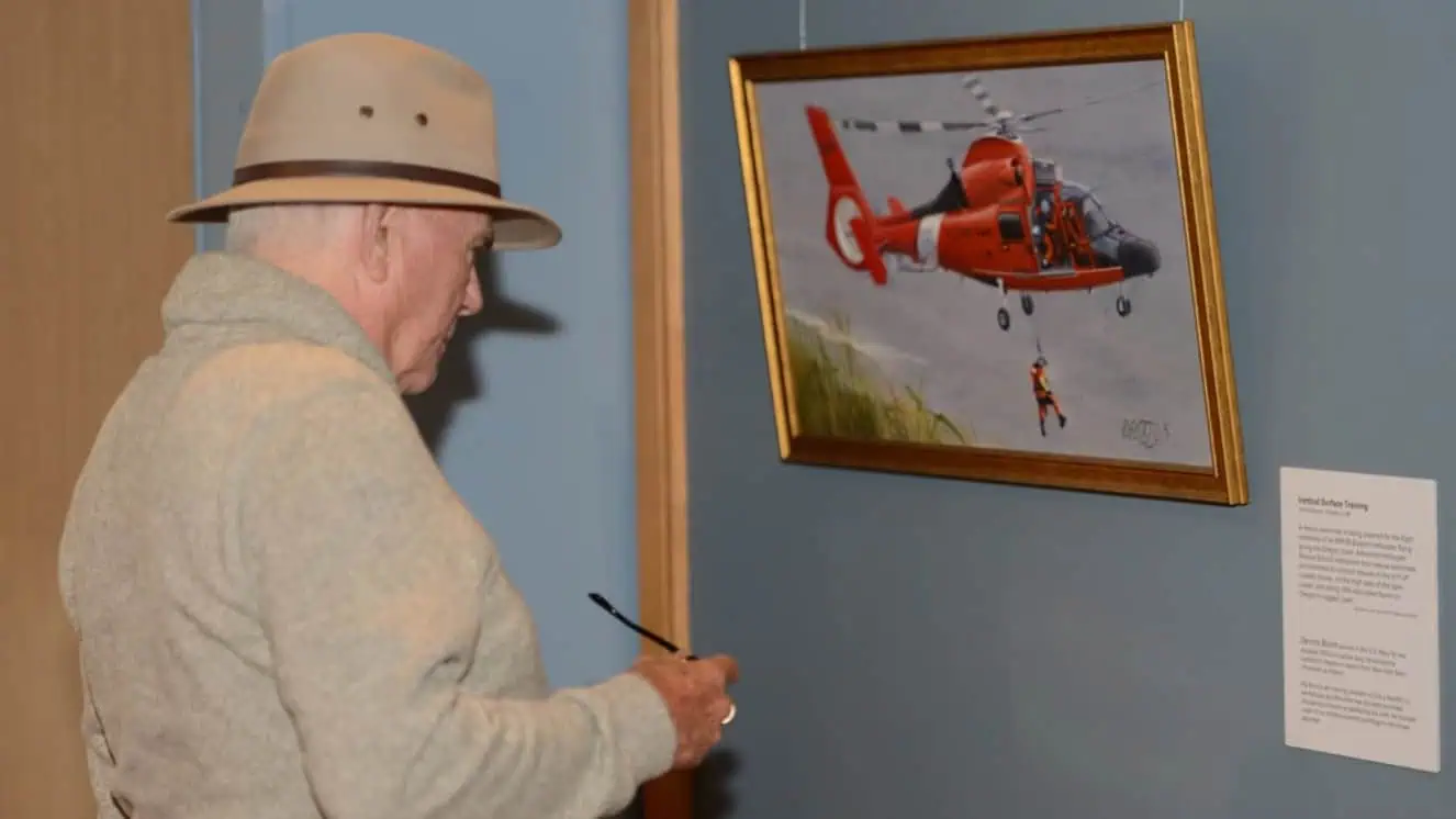 A visitor to the Coos History Museum looks at a piece of art from the Coast Guard Art Program. Military arts and crafts programs have helped troops since WWII.