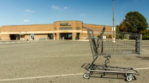 A shopping cart stands alone amidst a vacant parking lot following the commissary's closure at Joint Base Anacostia-Bolling. In a government shutdown, military pay and amenities are affected.