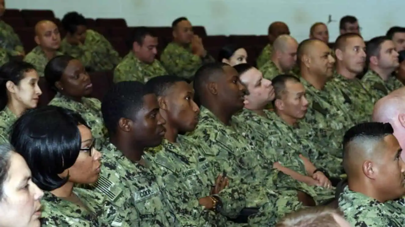 Navy recruitment meeting where a large number of Sailors are gathered.