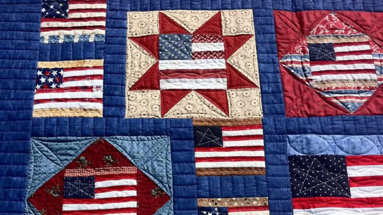 A Quilt of Valor with American flags on it.