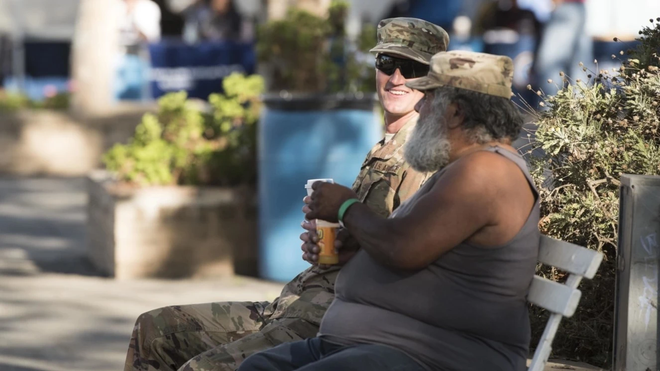 Homeless Veterans sitting and talking on a bench.