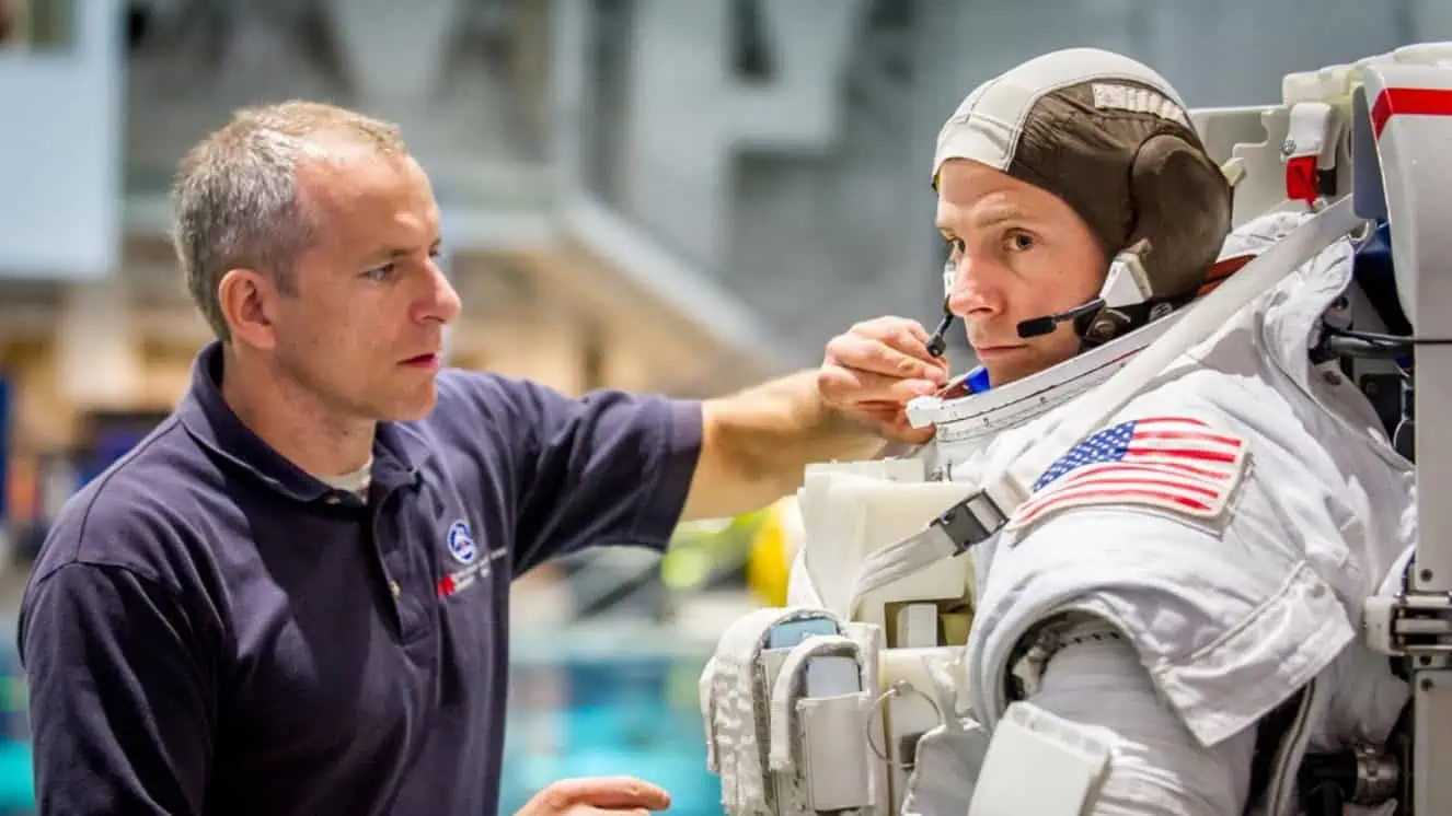 Canadian Space Agency astronaut David Saint Jacques helps Astronaut Col. Nick Hague prepare to be lowered into a pool with a mockup of the International Space Station (ISS) for Extravehicular Activity (EVA) training at the Johnson Space Flight Center's Neutral Buoyancy Laboratory (NBL) in Houston.