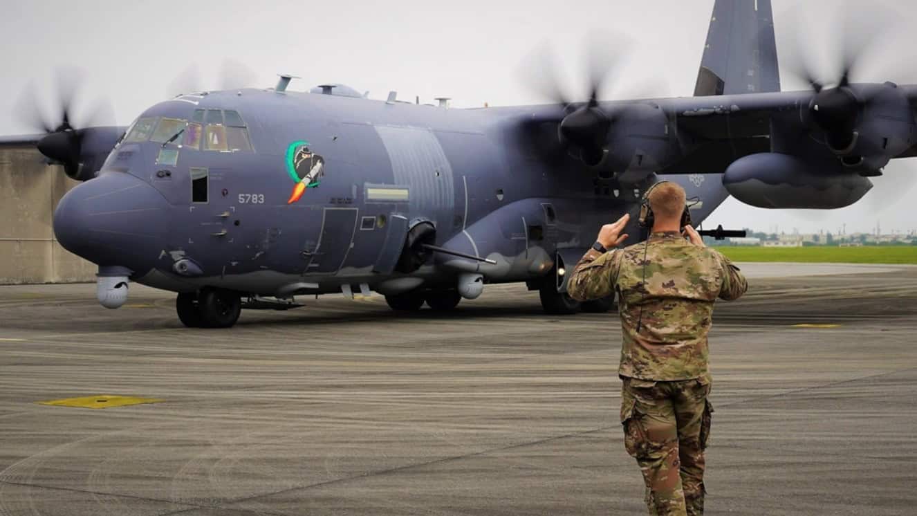 An Airman from the 73rd Special Operations Squadron marshals an AC-130J Ghostrider to its parking location after landing at Kadena Air Base on March 29, 2021.