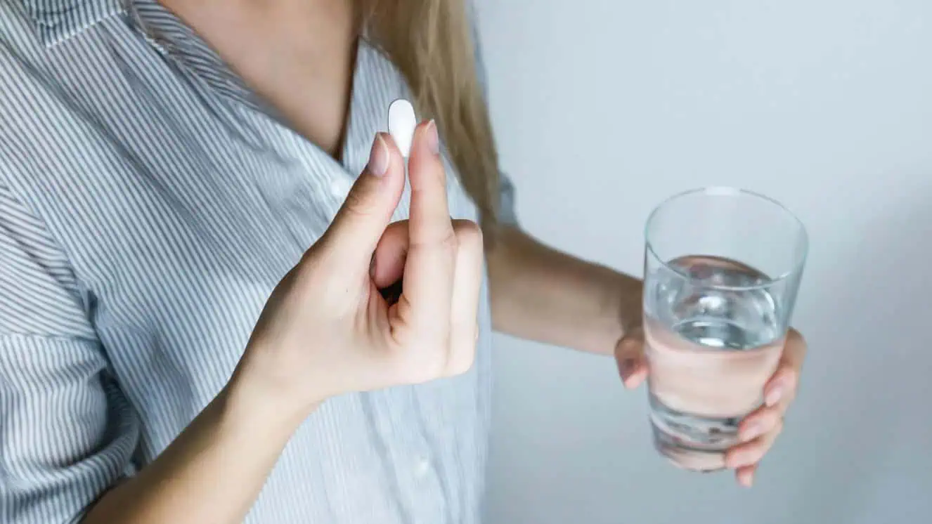 Woman taking an anti aging pill.