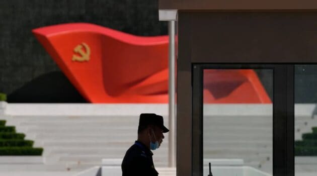 A security guard stands near a sculpture of the Chinese Communist Party flag at the Museum of the Communist Party of China on May 26, 2022, in Beijing in light of the Axis of Evil.