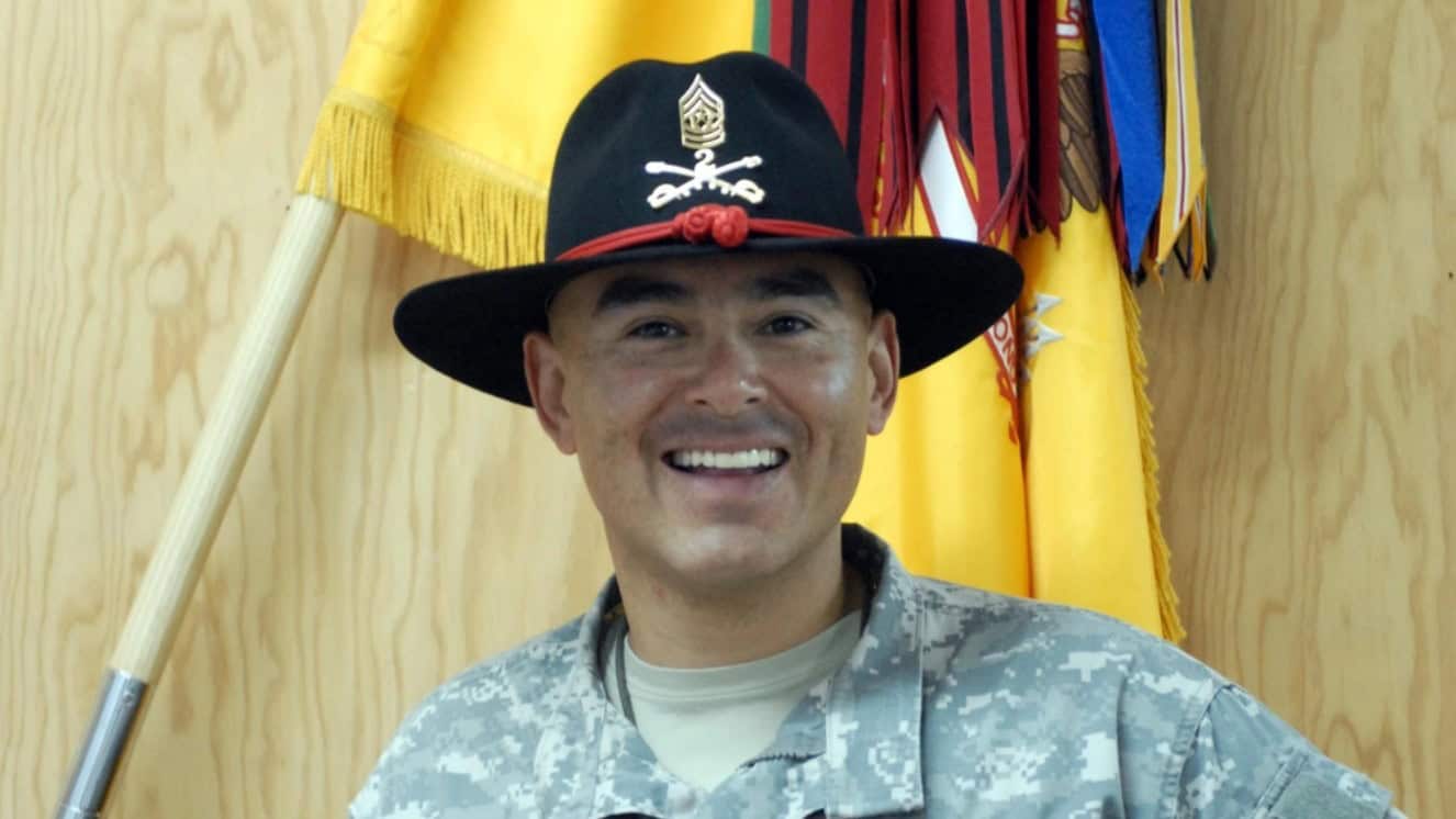 Comman Sgt. Maj. Victor Martinez, 2nd Stryker Cavalry Regiment, displays his Army stetson hat in front of the regimental colors. The Stetson is a long proud Army Cavalry tradition carried on by 2nd SCR.
