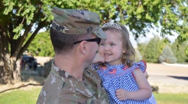 Military brat meaning has many facets as soldier holds his little girl.