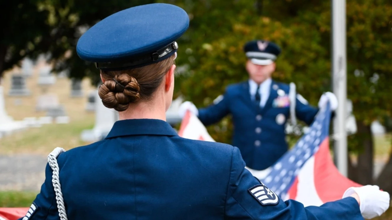 Folding a flag on Memorial Day and sharing Memorial Day Quotes with others.