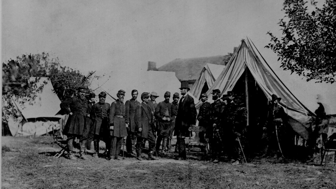 Sharing Civil War facts with Soldiers standing at camp.