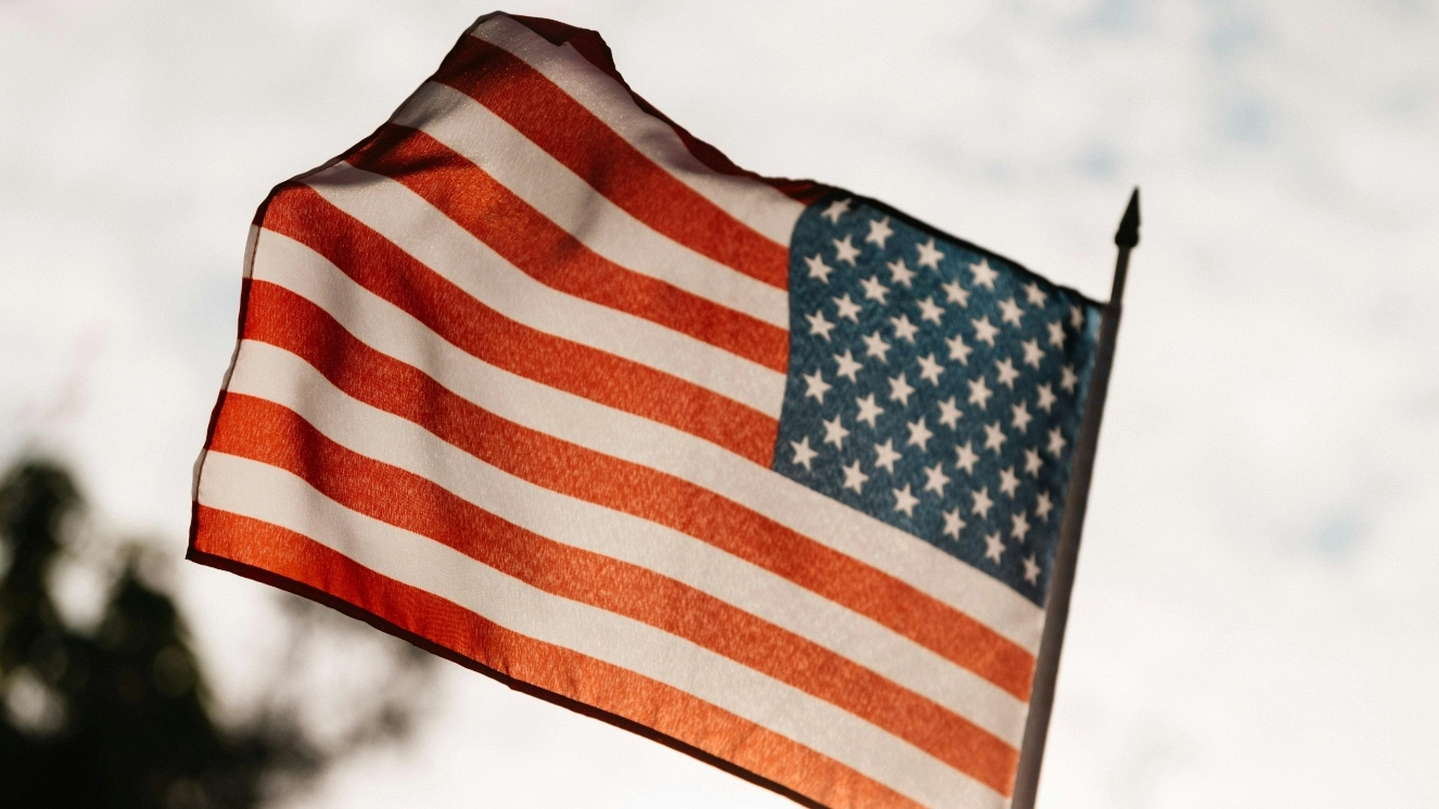 Happy Fourth of July as an American Flag waves in the wind.