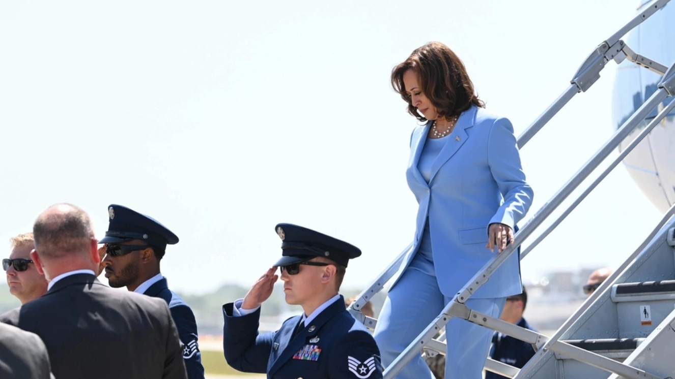 Kamala Harris, potential commander in chief walking down plane stairs.