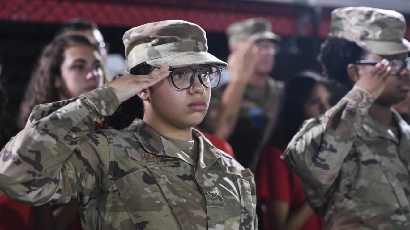 U.S. Air Force Airman 1st Class Shayla Harris, a member of the Health Services Management team in the 1st Special Operations Wing at Hurlburt Field, Florida, salutes during the playing of the national anthem at the opening of a Military Appreciation football game in Fort Walton Beach, Florida, October 7th in light of Military Appreciation Day.