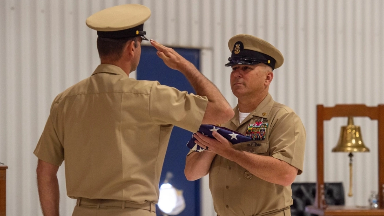 .S. Navy Master Chief Master-at-Arms James Meares, assigned to the aircraft carrier USS John C. Stennis (CVN 74), receives his flag during a flag passing ceremony at his retirement ceremony, after 30 years of service, at Center for Naval Aviation Technical Training Ceremonial Hangar, onboard Naval Air Station Oceana, June 03, 2022, told to enjoy your retirement.