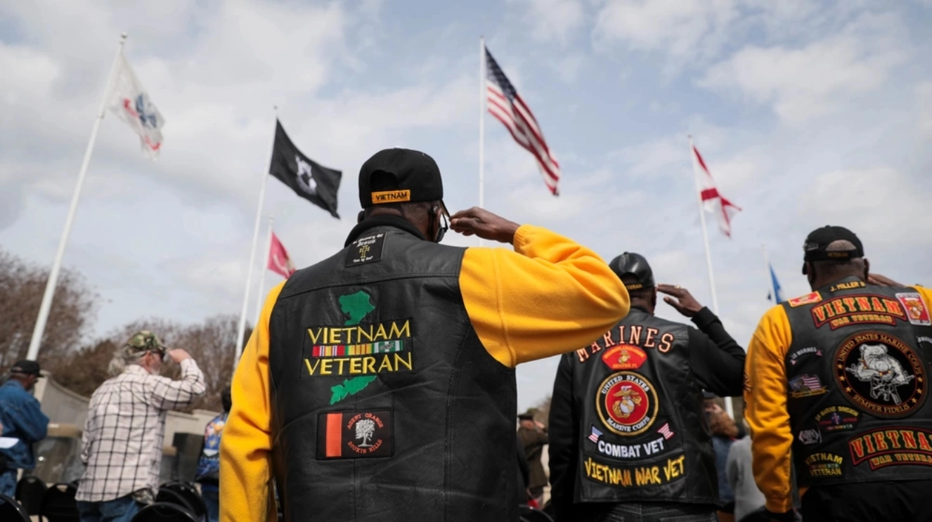 Vietnam Veterans saluting an American flag.