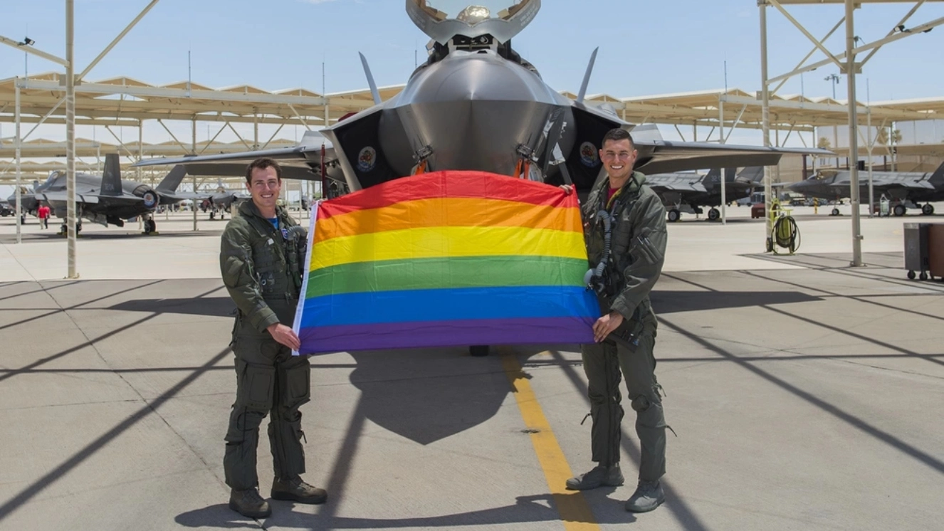 Maj. Tyler McBride, 62nd Fighter Squadron F-35A Lightning II instructor pilot, and Capt. Justin Lennon, 56th Training Squadron F-35 instructor pilot, hold an LGBTQ+ Pride flag after a Pride Month flyby June 26, 2020, at Luke Air Force Base, Ariz. McBride and Lennon performed the flyby over Luke AFB to celebrate and highlight the LGBTQ+ community and when Biden pardons lgbtq veterans.